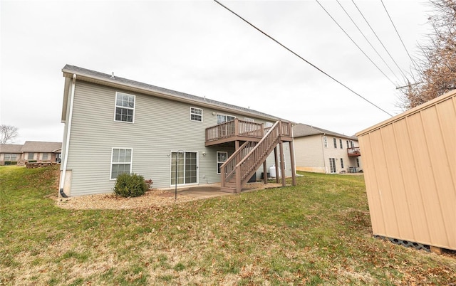 rear view of property featuring a lawn, a patio area, and a deck