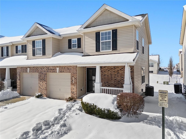 view of front of property featuring a porch, a garage, and central AC