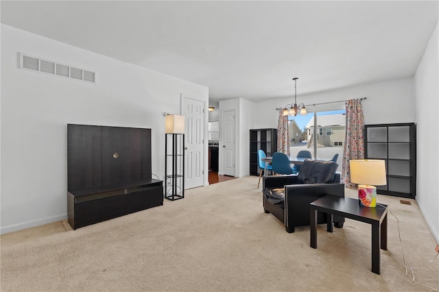 carpeted living room with a notable chandelier