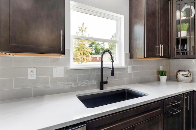 kitchen featuring decorative backsplash, sink, and dark brown cabinets