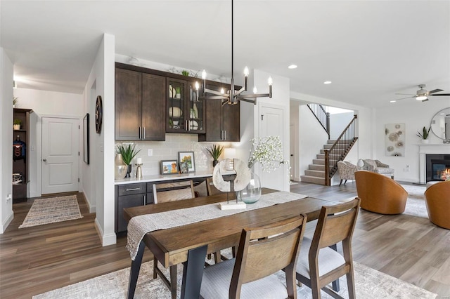 dining room featuring wood-type flooring and ceiling fan with notable chandelier