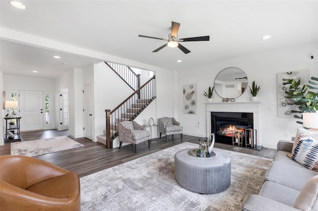 living room featuring ceiling fan and dark wood-type flooring