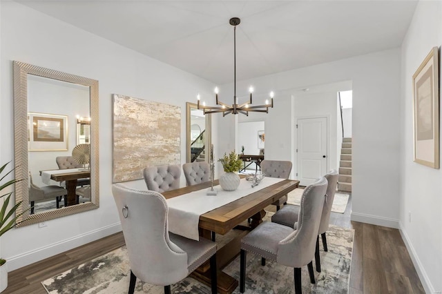 dining space featuring dark wood-type flooring and a chandelier