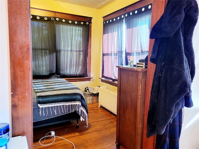 bedroom featuring radiator and hardwood / wood-style floors