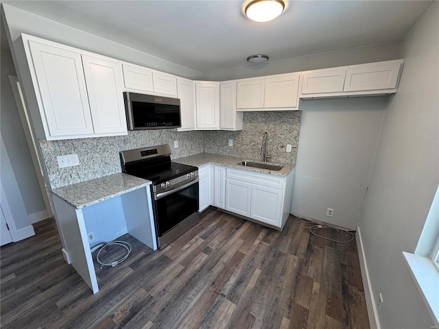 kitchen featuring sink, decorative backsplash, light stone countertops, white cabinetry, and stainless steel appliances