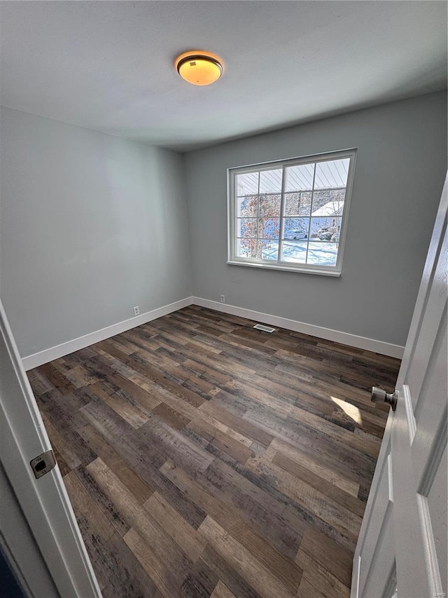 spare room featuring dark wood-type flooring