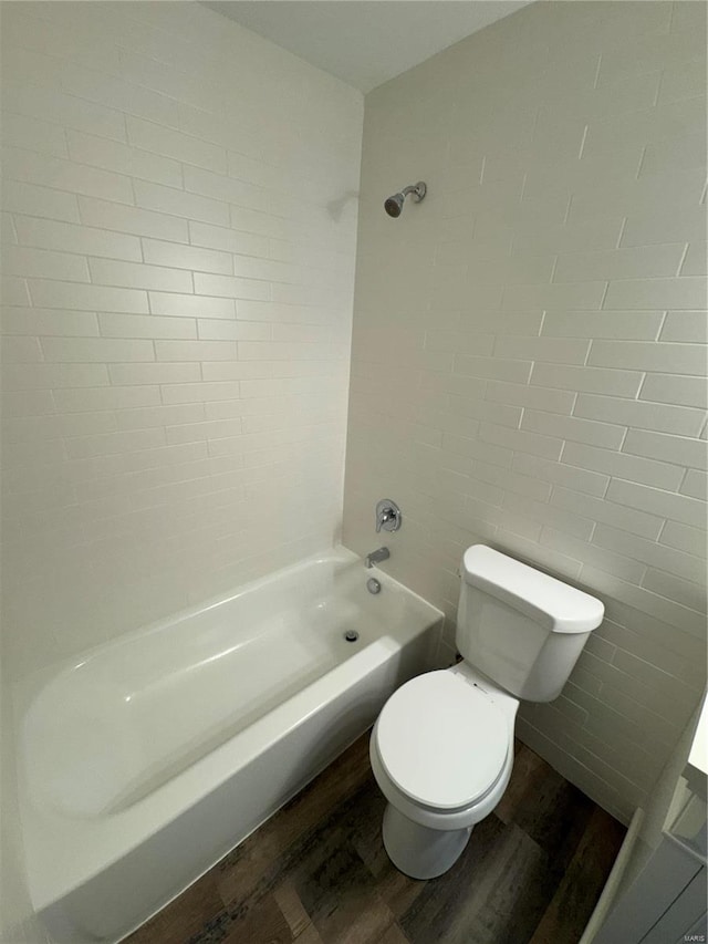 bathroom featuring hardwood / wood-style flooring, shower / bathtub combination, and toilet