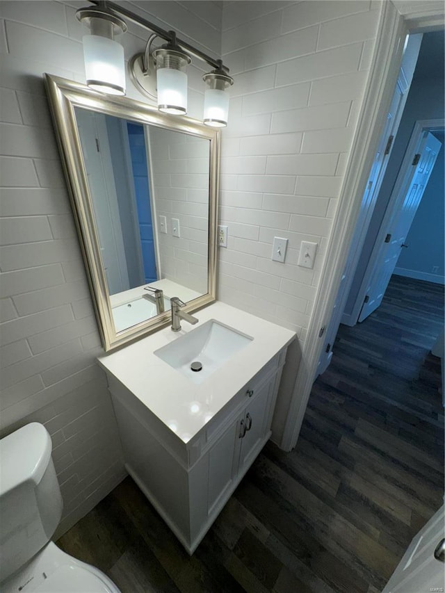 bathroom with hardwood / wood-style floors, vanity, and toilet