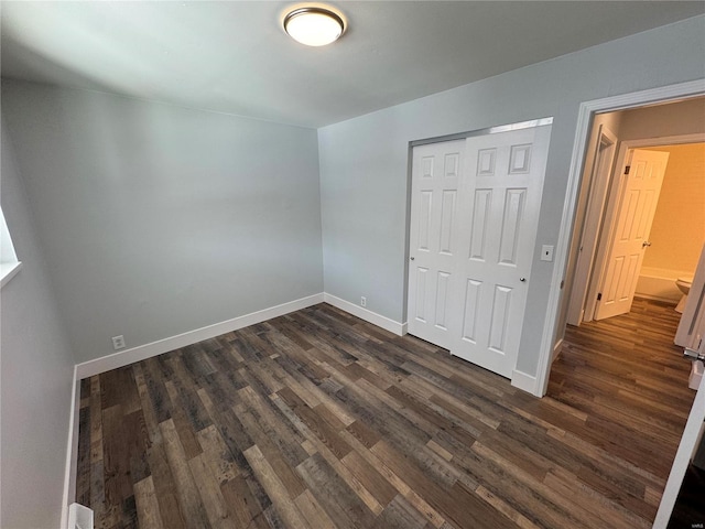 unfurnished bedroom featuring dark hardwood / wood-style floors and a closet