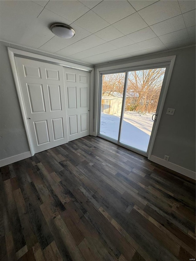 unfurnished bedroom with access to outside, dark hardwood / wood-style flooring, and a closet