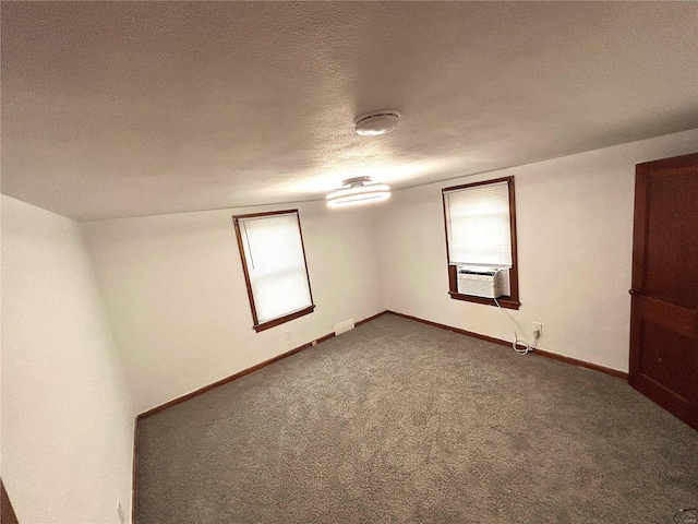 spare room featuring cooling unit, carpet floors, and a textured ceiling