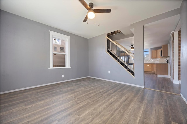 unfurnished living room with ceiling fan and dark hardwood / wood-style floors