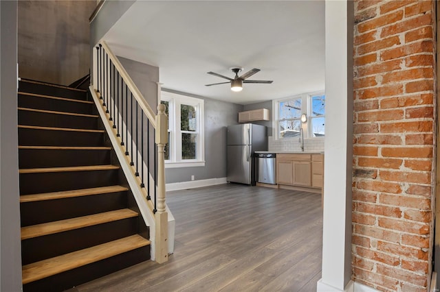 stairs featuring hardwood / wood-style floors, ceiling fan, and sink