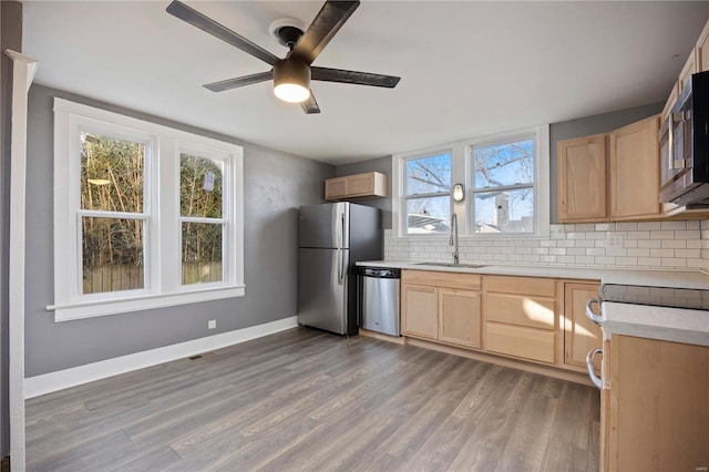 kitchen with backsplash, light brown cabinets, sink, and appliances with stainless steel finishes