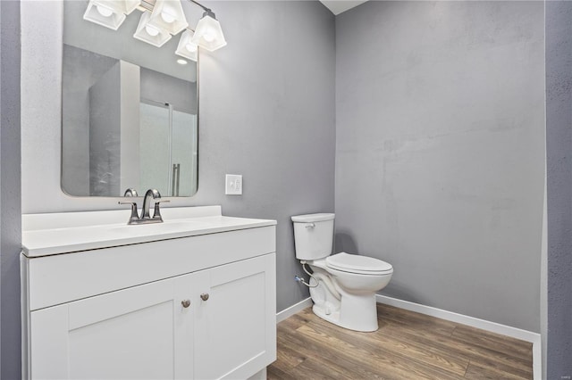 bathroom with vanity, toilet, and wood-type flooring