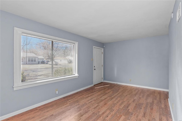 unfurnished room featuring a healthy amount of sunlight and wood-type flooring