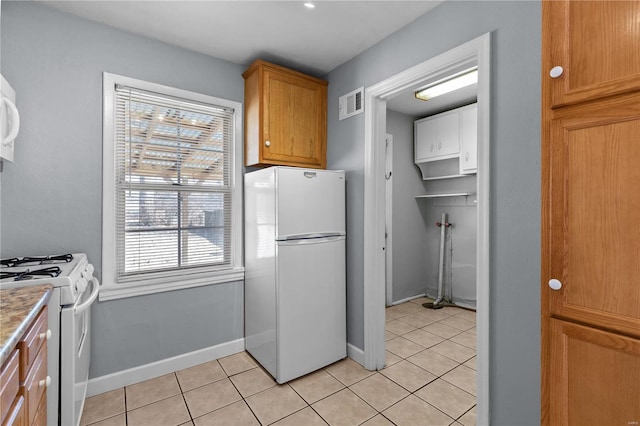 kitchen featuring light tile patterned floors and white appliances