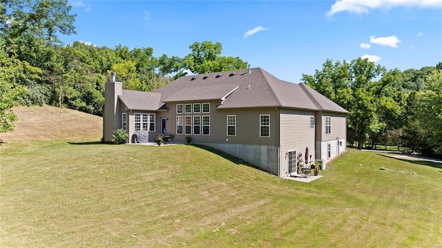 back of property featuring a lawn and a chimney