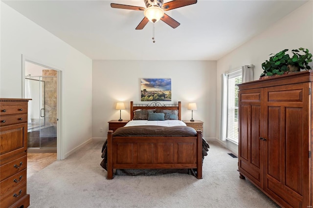 bedroom with light carpet, baseboards, a ceiling fan, and ensuite bathroom