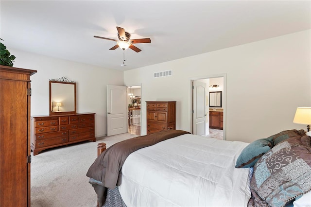 bedroom featuring ensuite bath, ceiling fan, visible vents, and light colored carpet