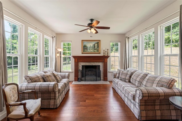 sunroom / solarium featuring ceiling fan and a fireplace with flush hearth