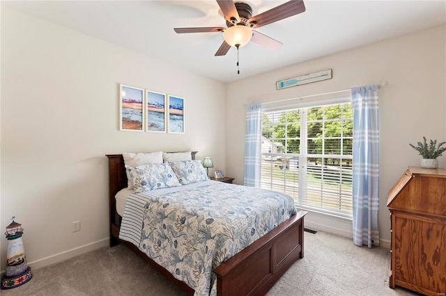 bedroom featuring a ceiling fan, light colored carpet, and baseboards