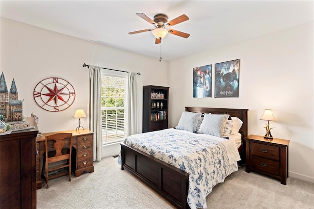 bedroom featuring light carpet, baseboards, and a ceiling fan