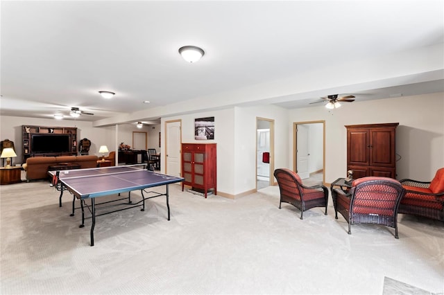 recreation room with light carpet, ceiling fan, and baseboards