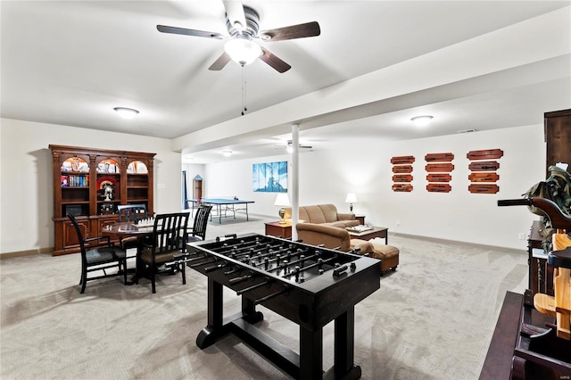 recreation room featuring light carpet, ceiling fan, and baseboards