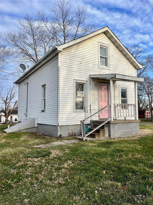 rear view of house featuring a lawn