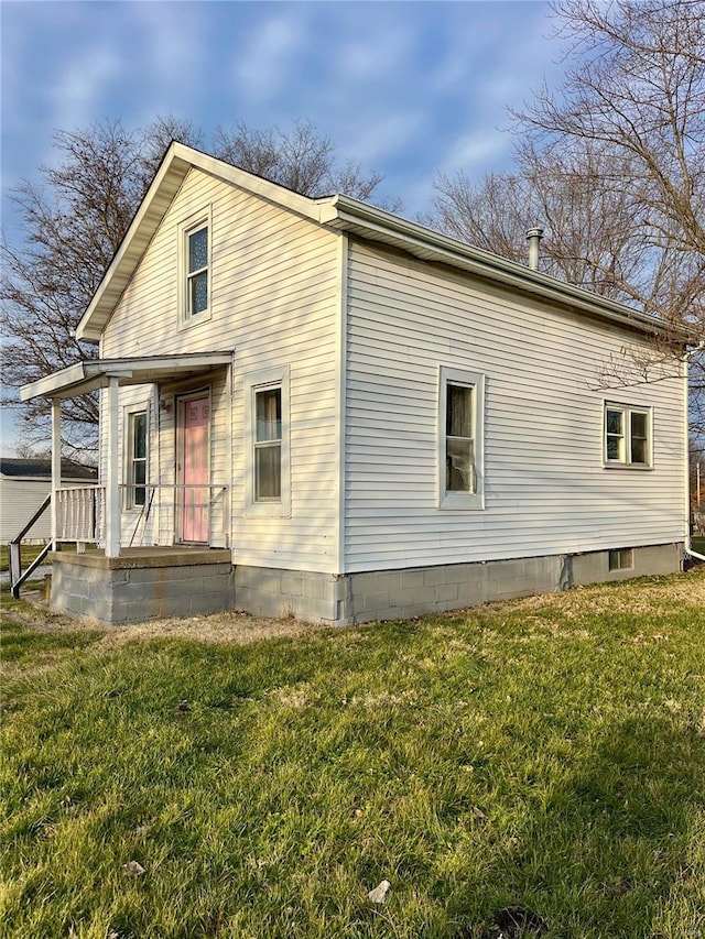 rear view of property featuring a lawn