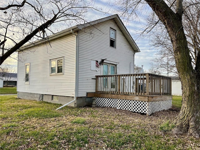 rear view of property featuring a lawn and a wooden deck