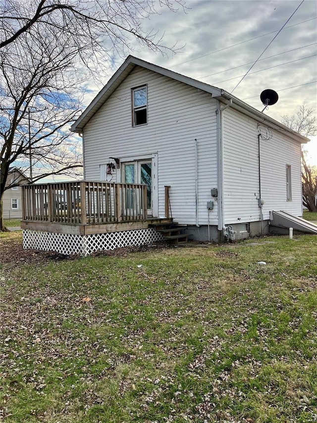 rear view of property with a yard and a deck