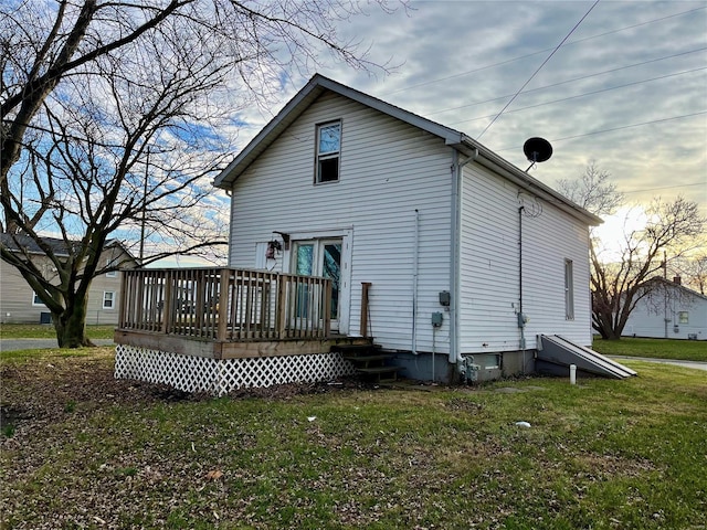 back of house with a wooden deck and a yard