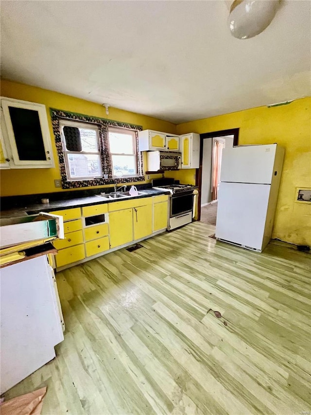 kitchen featuring white appliances, sink, and light hardwood / wood-style flooring