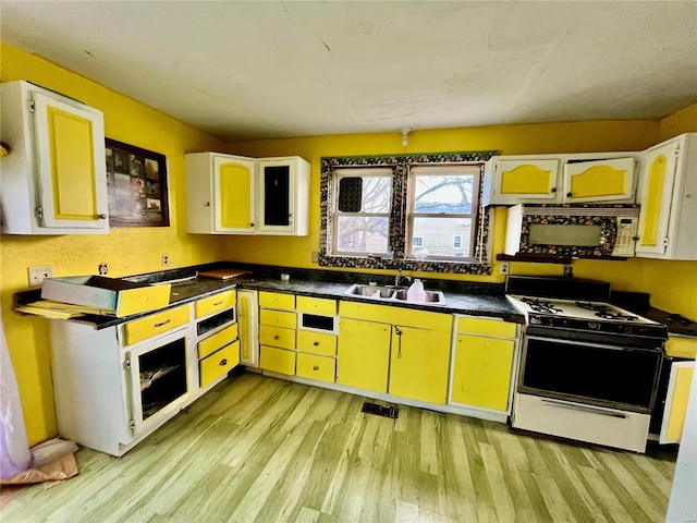 kitchen with white range with gas stovetop, white cabinetry, light hardwood / wood-style flooring, and sink