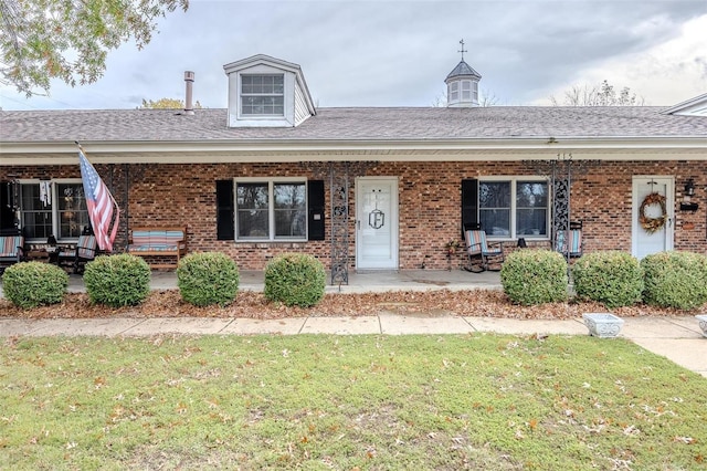 view of front of house with a porch and a front lawn