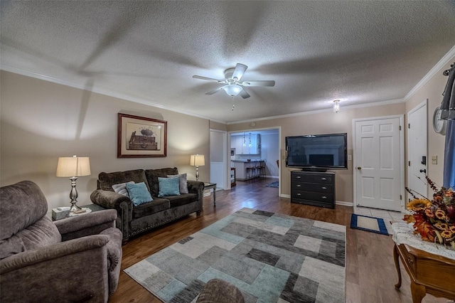 living room with a textured ceiling, dark wood-type flooring, ceiling fan, and crown molding