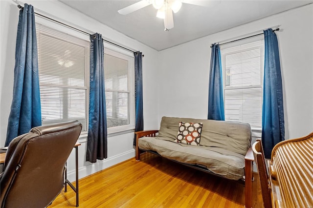 living area with ceiling fan and hardwood / wood-style flooring