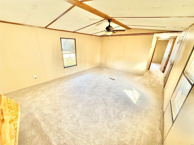 spare room with lofted ceiling with beams, light colored carpet, and ceiling fan