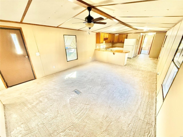 unfurnished living room with light carpet, lofted ceiling with beams, and ceiling fan