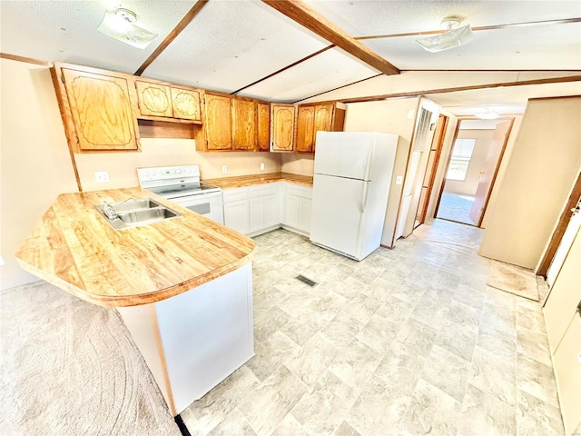 kitchen with kitchen peninsula, white appliances, sink, vaulted ceiling with beams, and white cabinetry