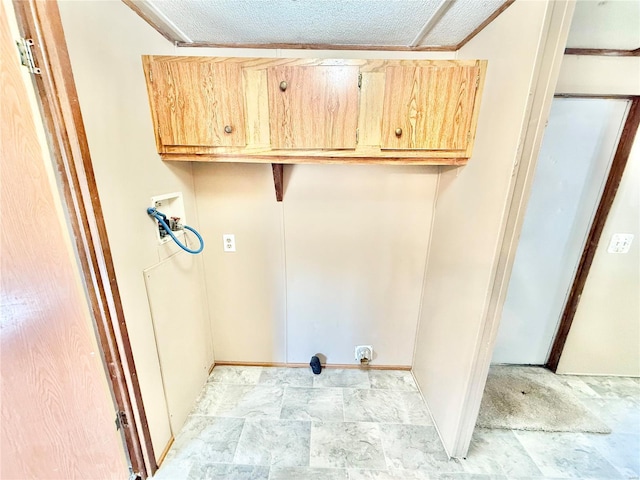 clothes washing area featuring cabinets, washer hookup, electric dryer hookup, a textured ceiling, and ornamental molding