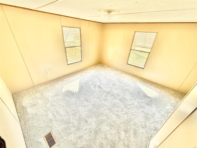 spare room featuring carpet floors and a textured ceiling