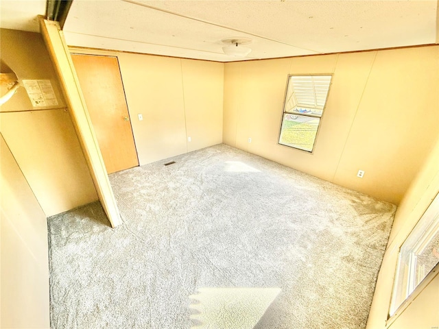 carpeted spare room featuring a textured ceiling