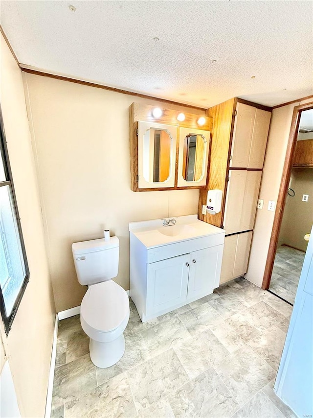 bathroom featuring vanity, toilet, and a textured ceiling