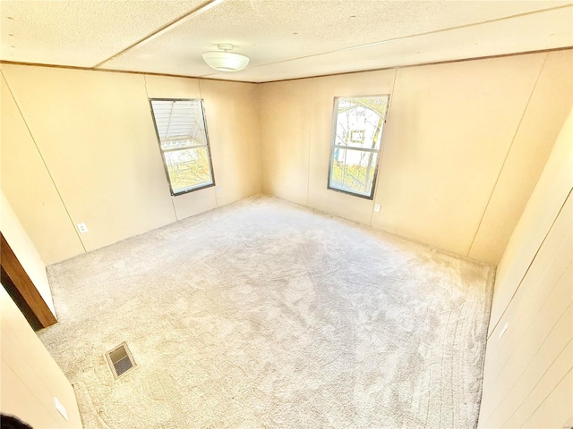 unfurnished room with a textured ceiling and carpet floors