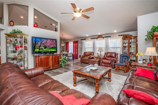 living area featuring high vaulted ceiling, ceiling fan, and wood finished floors