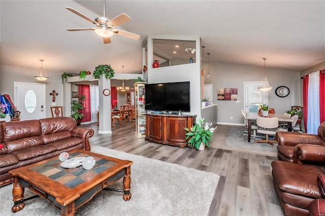 living room featuring a wealth of natural light, light wood-style floors, ceiling fan, and high vaulted ceiling