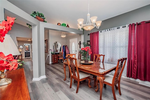 dining room featuring a notable chandelier, baseboards, and wood finished floors